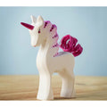 Unicorn figurine with pink mane and tail on a wooden surface