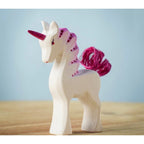 Unicorn figurine with pink mane and tail on a wooden surface