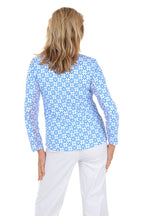 Woman wearing a blue floral patterned shirt on a white background. Back shot.