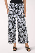 Person wearing black and white patterned pants on a white background