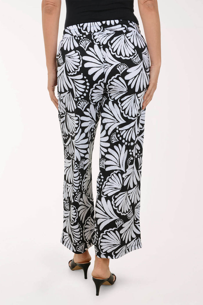 Black and white butterfly-patterned pants worn by a person on a white background