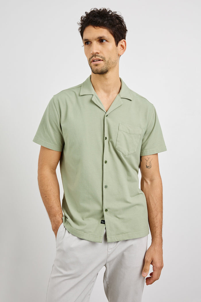 Flint Collared Button Shirt with Short Sleeves and a Chest Pocket in Sage Colorway. Front View Shown on Model.