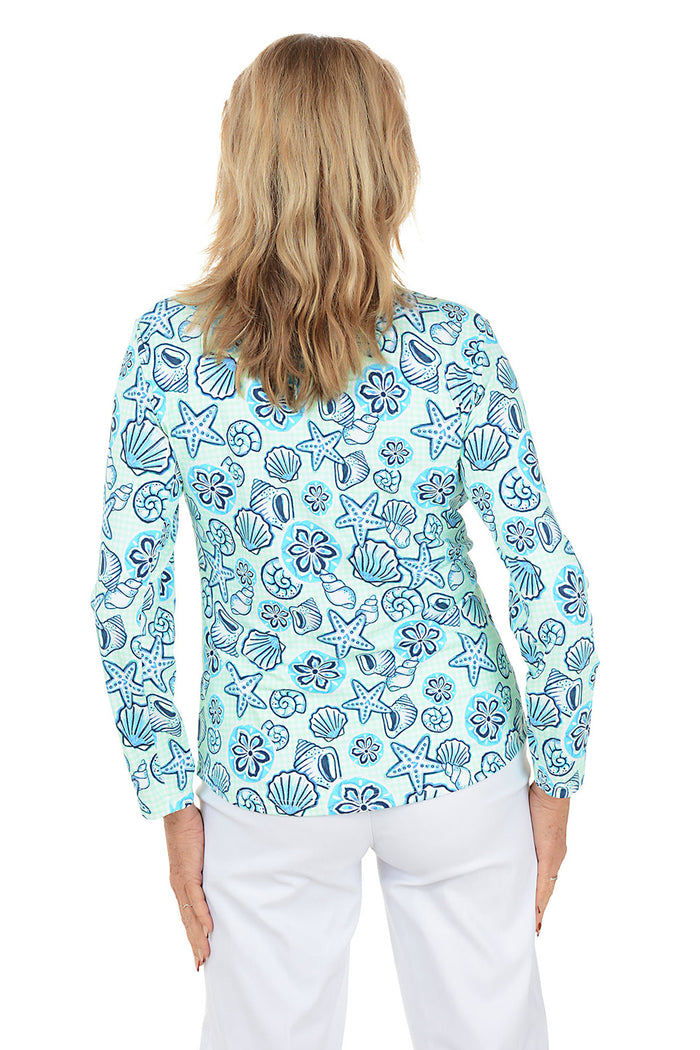 Woman wearing a blue floral patterned blouse on a white background. Back shot.