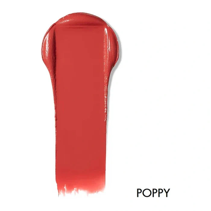 Swatch of lip & cheek cream in the shade 'Poppy'. Deep warm pink-red shade.