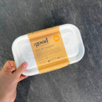 Gluten-Free Mac 'N' Cheese from The Good Farm Shop, organic and ready to heat, held in hand over dark surface