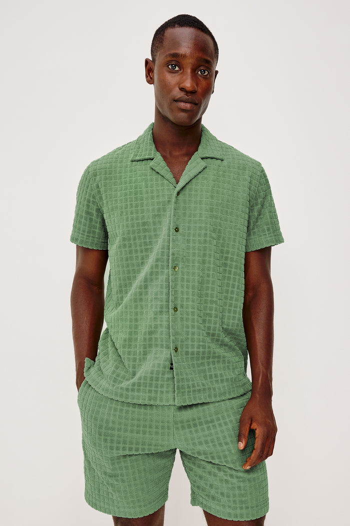 Maverick Short Sleeve Shirt in French Terry With Jacquard Pattern, Notched Collar, Front Buttons, and Classic Fit in Green Bay Grid Colorway - Upper Body Front View Featured on Model