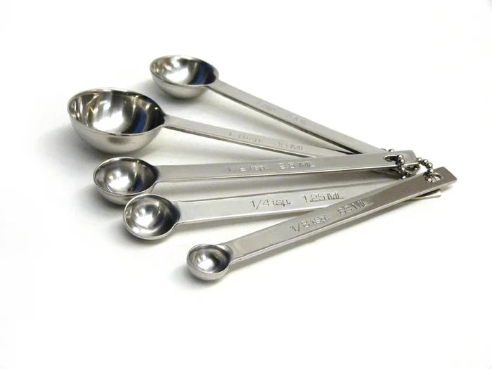 Set of stainless steel measuring spoons on a white background