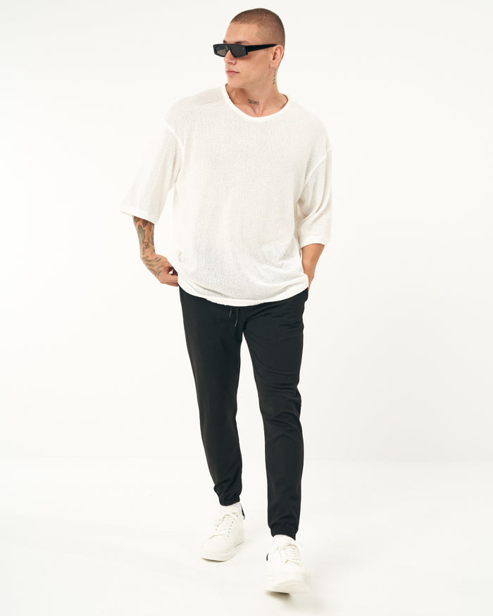 Martin Valen black men's jogger with elastic cuffs, loose fit, three-quarter view showing right leg