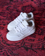 Martin Valen white men's high-top sneakers, overhead close-up on a red patterned rug showing logo on side