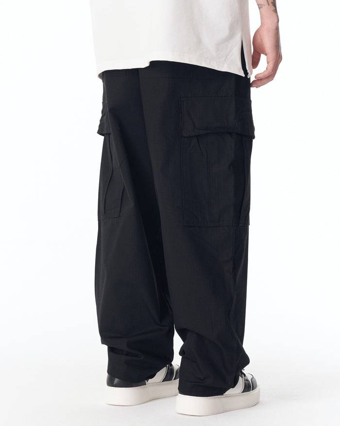 Martin Valen relaxed-fit black cargo pants, low-side view showing flap cargo pocket and loose hem