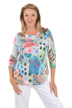 A woman wearing a multi-colored 3/4 sleeve top.