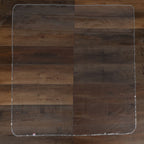 The Nuby US No-Mess Mealtime Mat, a clear rectangular floor protector with rounded corners, is laid flat on dark brown hardwood flooring; easy to clean for effortless maintenance.