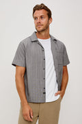 Ohana Button-Up Shirt in Textured Shirting WIth Short Sleeves, Collar, and Relaxed Fit in Charcoal Chambray Colorway - Upper Body Front View Featured on Model