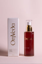 OmVeda hair tonic bottle and box, amber liquid with gold pump, 100 ml