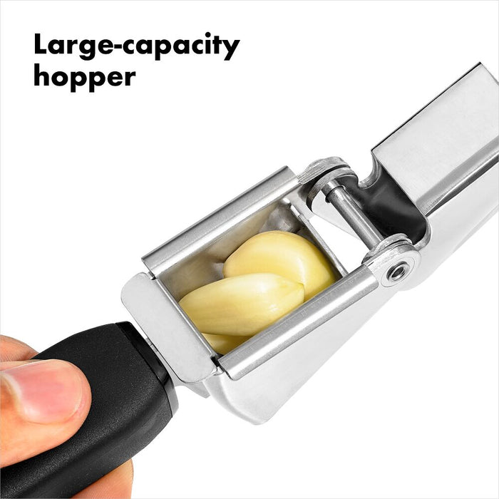 Garlic press with a large-capacity hopper holding cloves of garlic on a white background.