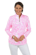 Woman wearing a pink floral patterned shirt with a white background. Second front shot.