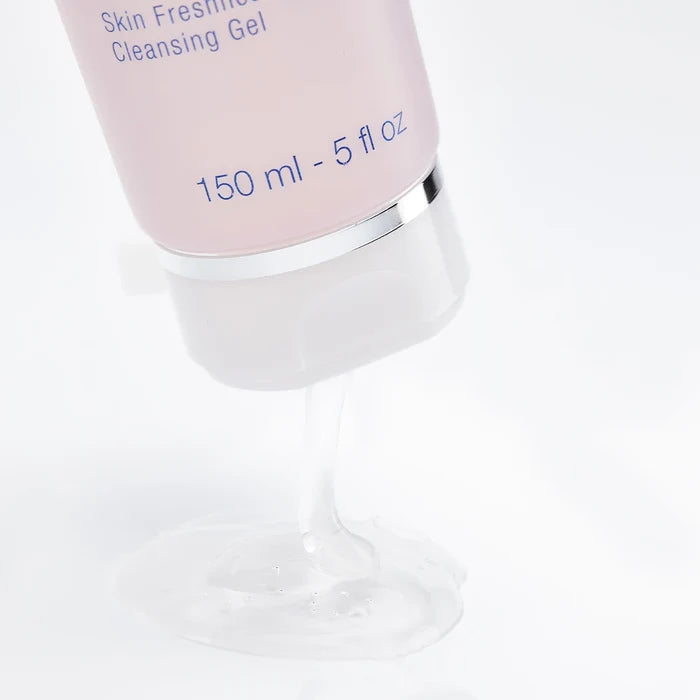 Close-up of clear cleansing gel pouring from a pink tube, highlighting texture of Rosée Visage Skin Freshness Cleansing Gel | Phytomer for skincare and wellness.