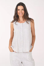 Woman wearing a light gray sleeveless top and pants on a white background