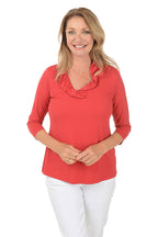 Woman wearing a red blouse with a ruffled collar on a white background