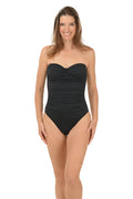 Woman wearing a black strapless swimsuit on a white background